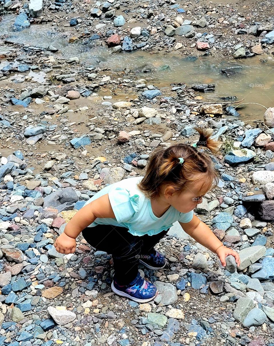 niña jugando con piedritas