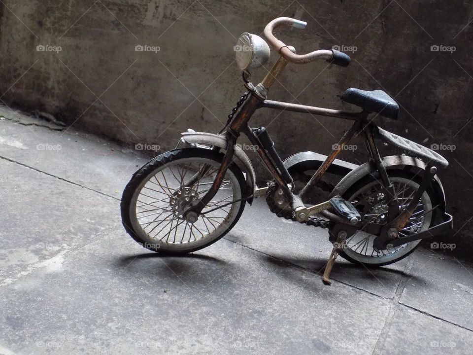 Old, rusty and broken toy bicycle