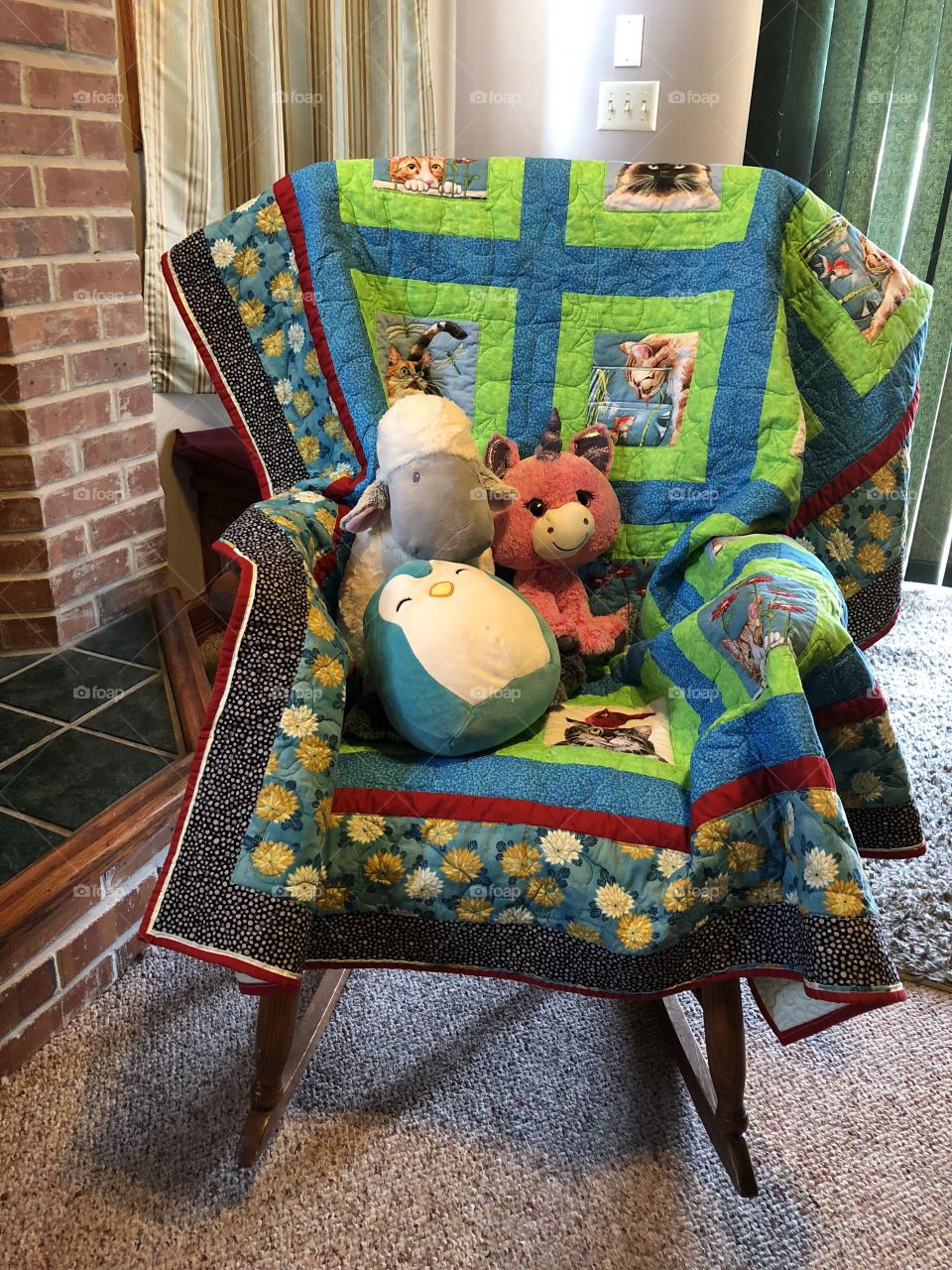 Rocking chair with quilt next to fireplace 