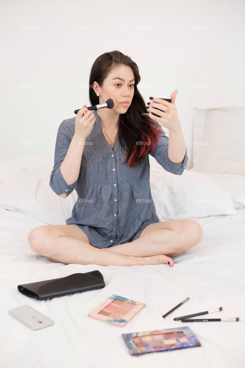 Portrait of a woman putting on makeup