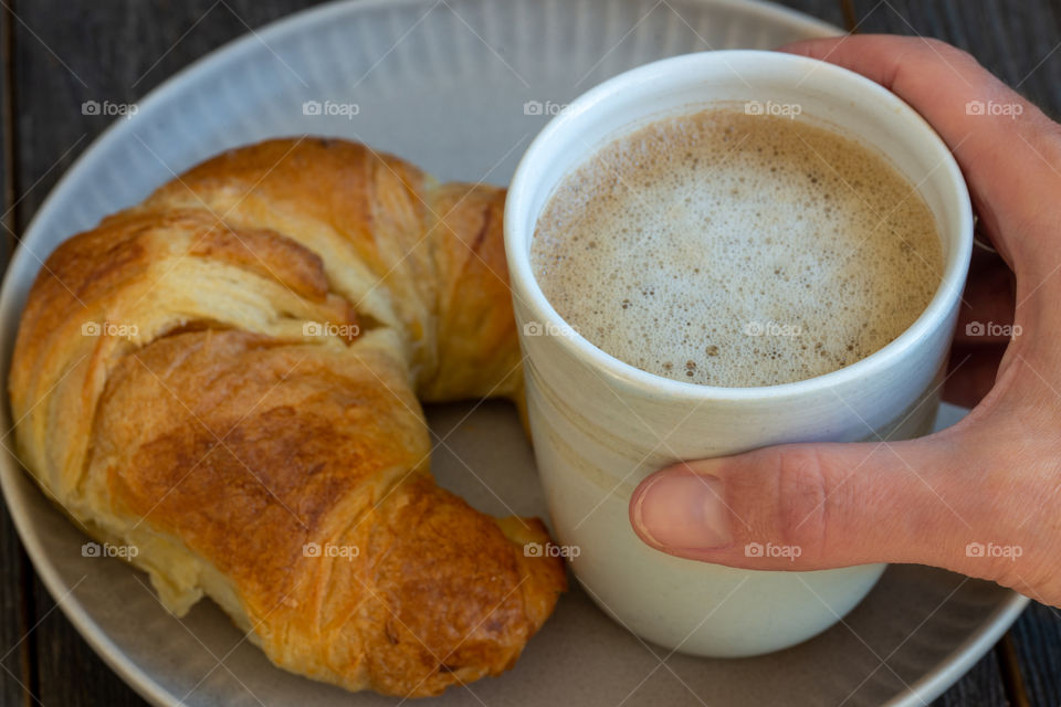 hand holding cup of milk coffee