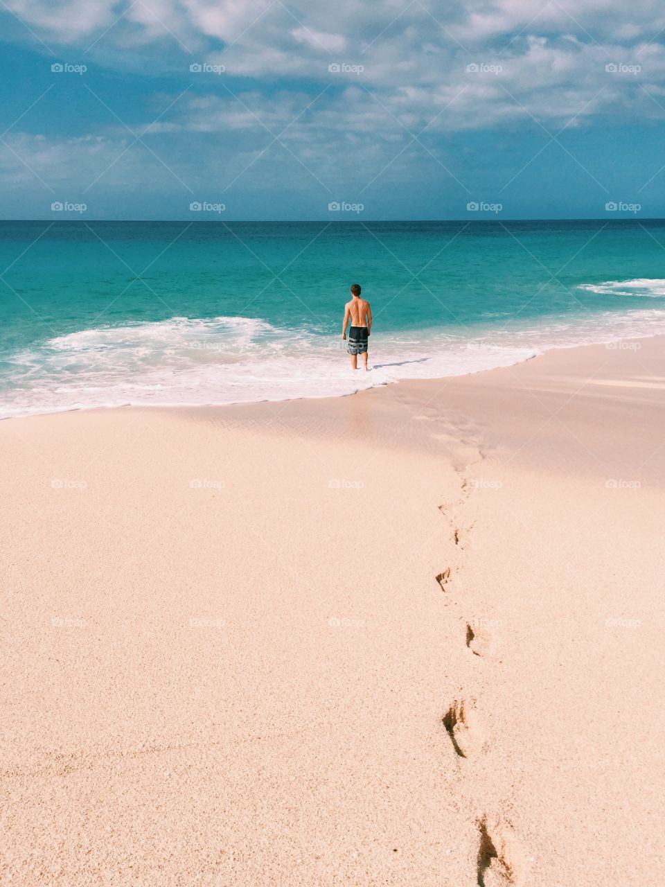 Man entering the beach on the north shore of Oahu.