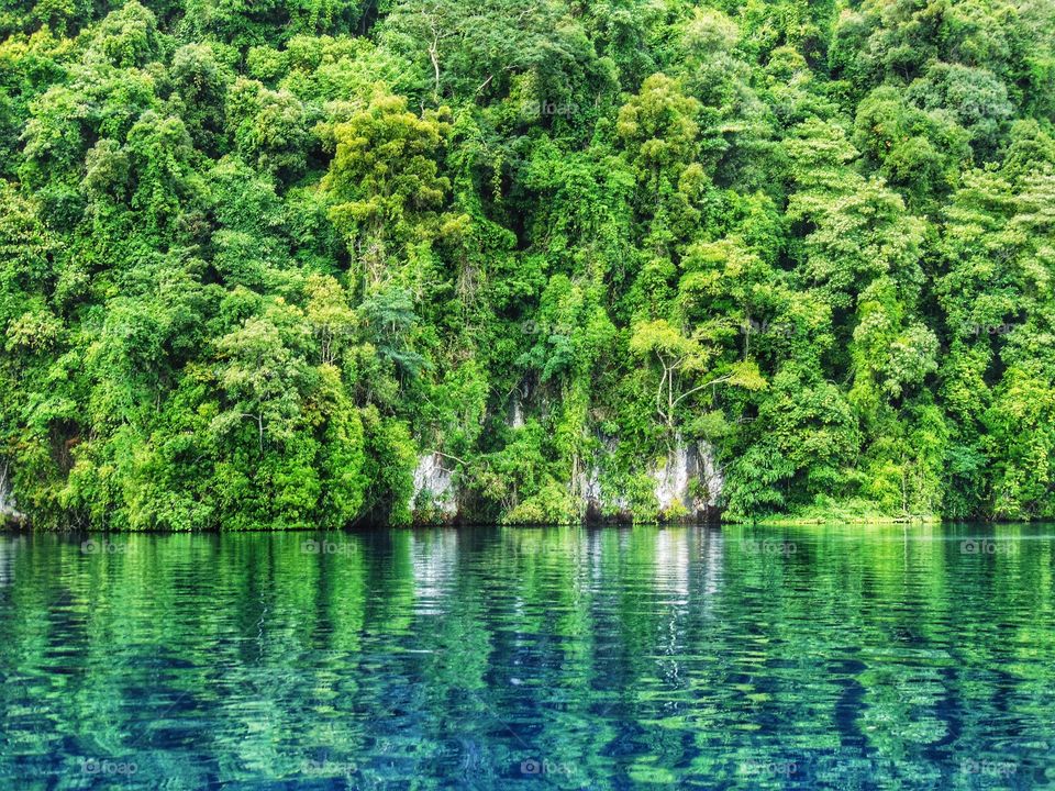 reflection - stones wall and clear water of matano lake