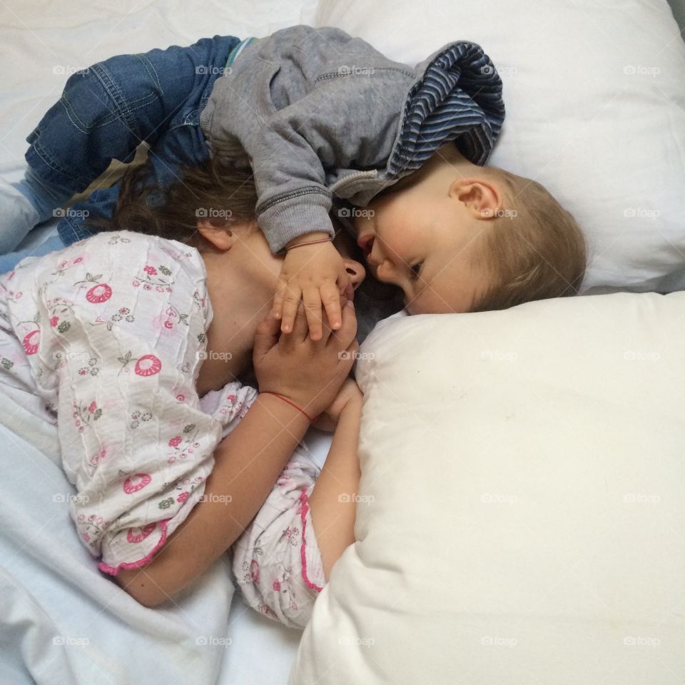 Brother and sister lying on bed