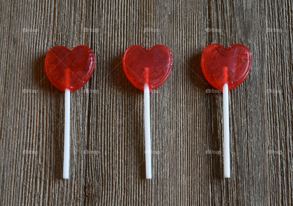 Heart shaped lollipops on a wood background