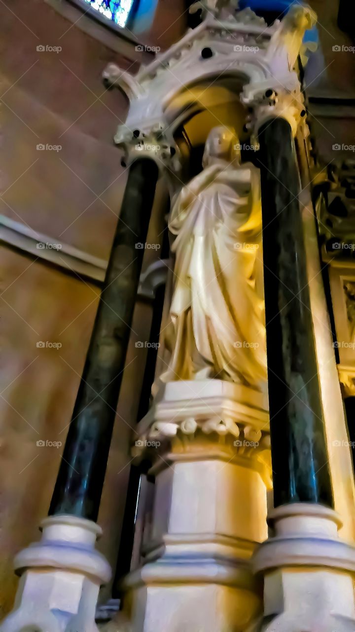 A tall marble statue looks over me inside a church.Belfast,Northern Ireland