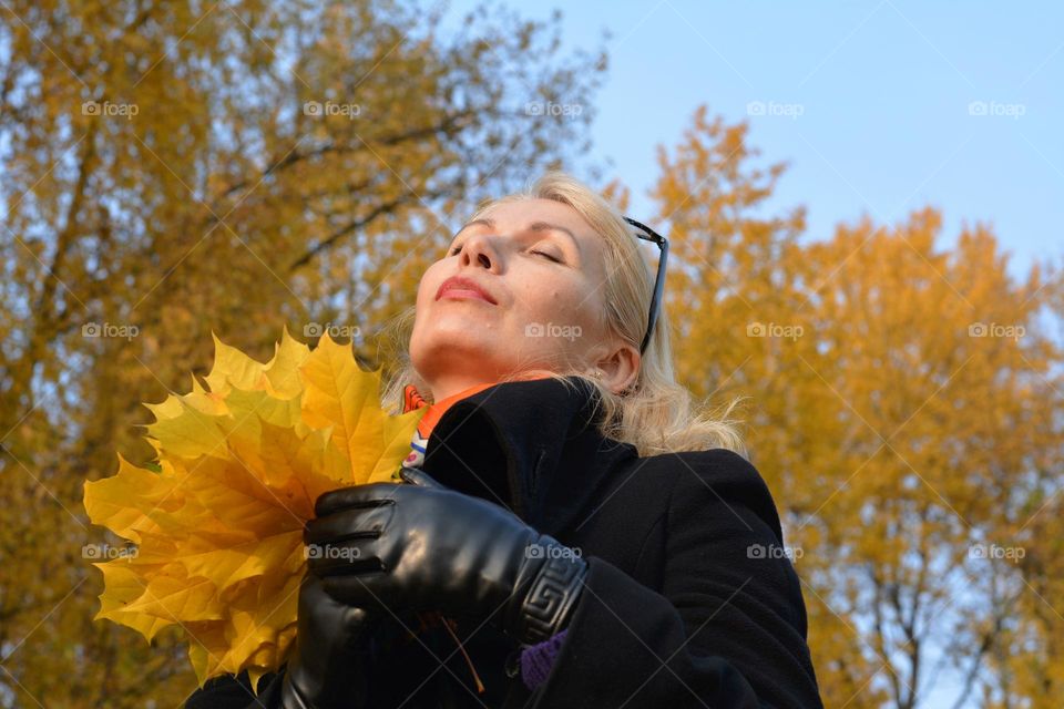 woman with yellow colour leaves autumn time, nature lovers