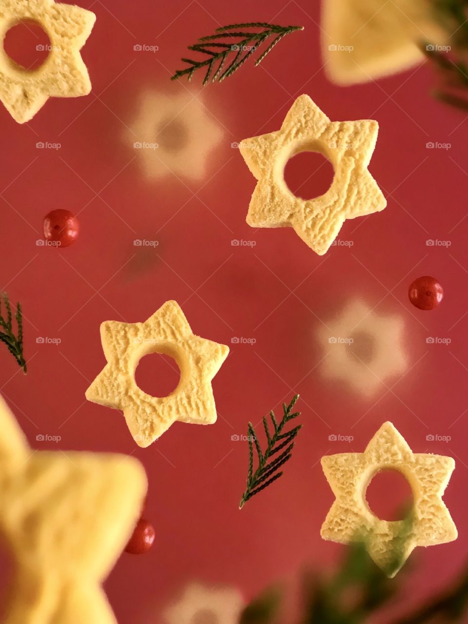 levitating cookies in the shape of a Christmas star, holiday pattern on a red background