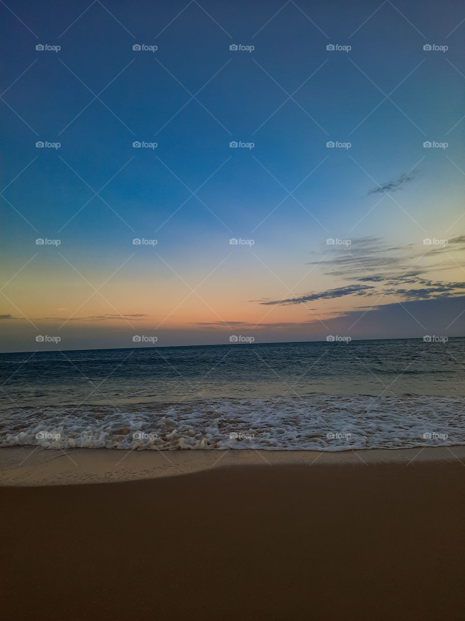 Perfect and calming view of a beautiful evening with sun setting in the horizon. Colours, clouds beautiful skies with clear waters and sand.