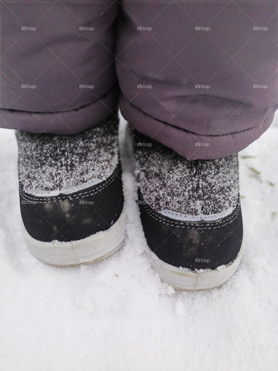 winter children's shoes, felt boots, children's legs in boots go through the November snow, shoes, feet, snow.