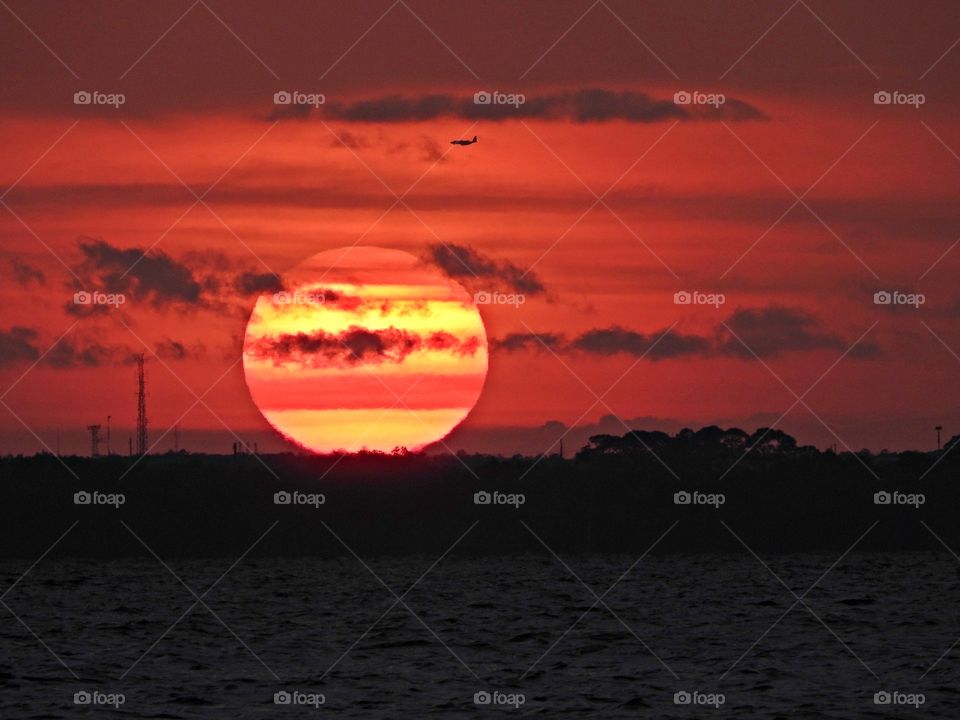 
Notice the size of the plane in the upper corner.  I am mesmerized at the size and beauty of the sun as it passes behind the clouds. Sunsets with their clearly delineated endings are difficult not to interpret as the last act, the final curtain call