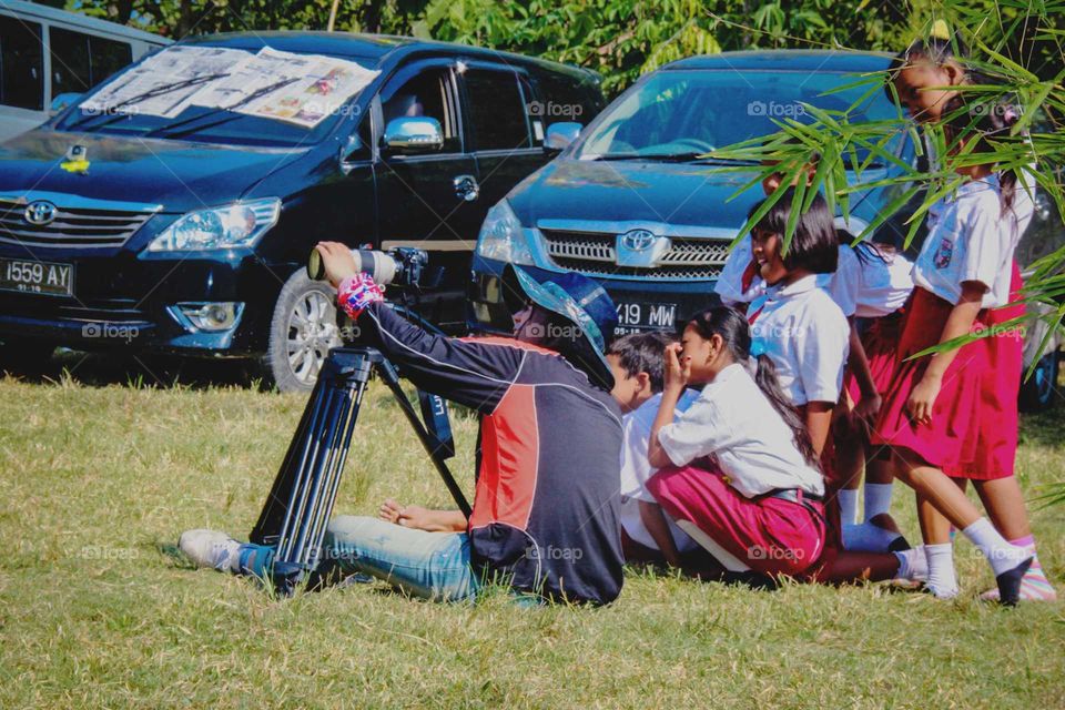 children watching how a photographer works with his camera