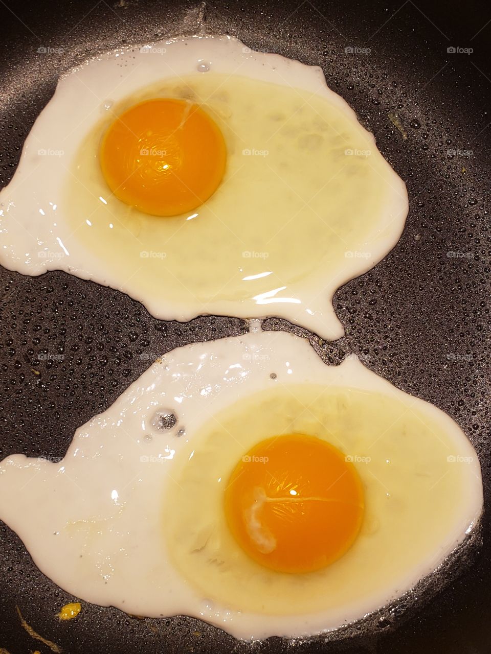 2 sunny-side-up eggs in a frying pan