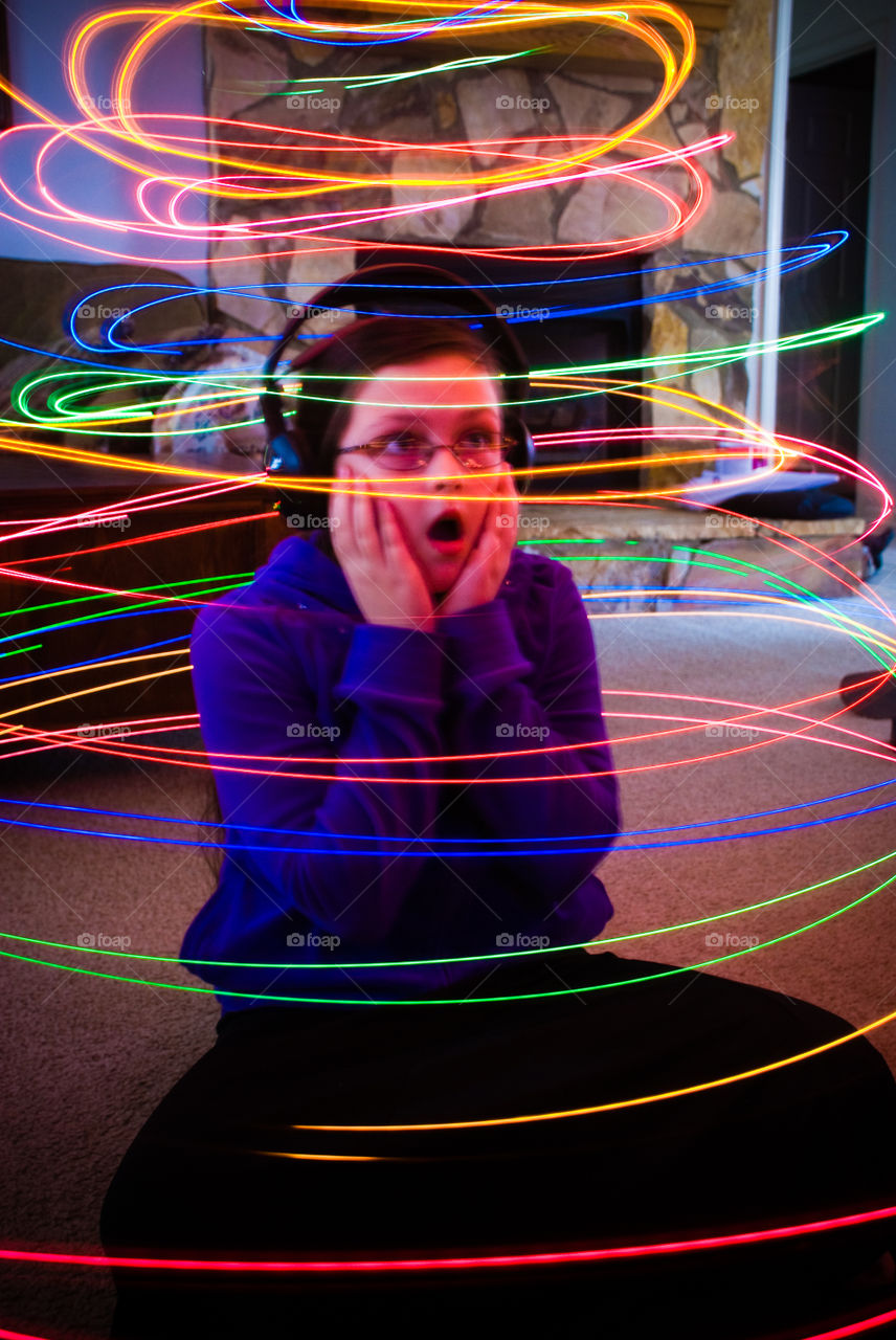 Shocked boy with headphone inside light trail