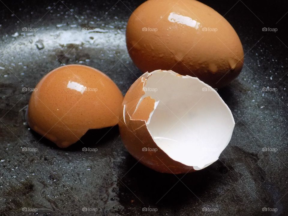 Chicken eggs and shells on a frying pan