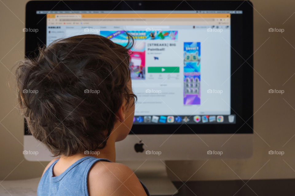 Boy using Apple computer desktop 
