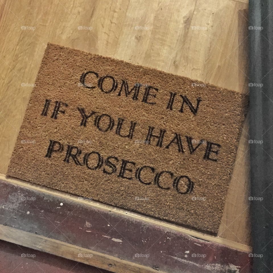 Joke doormat saying come in if you have prosecco. 