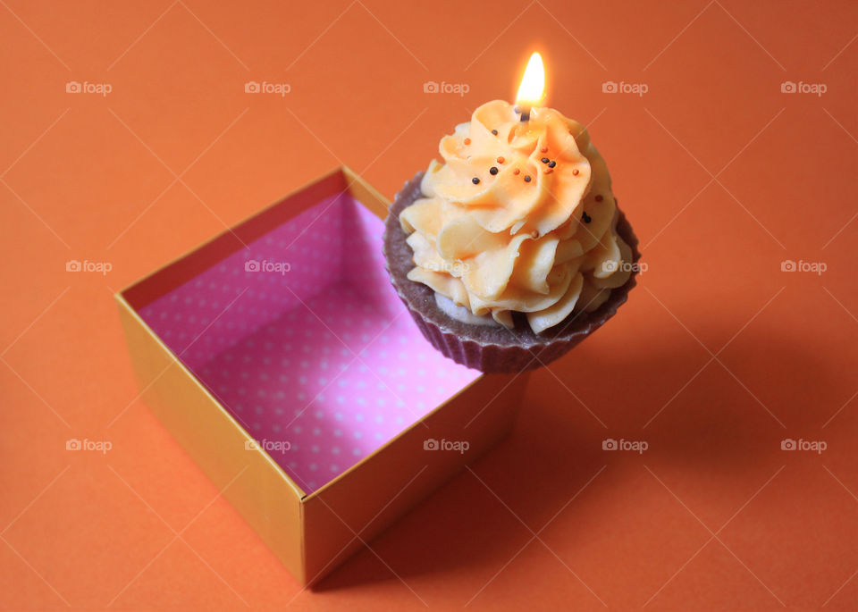 A candle cake on a gift box