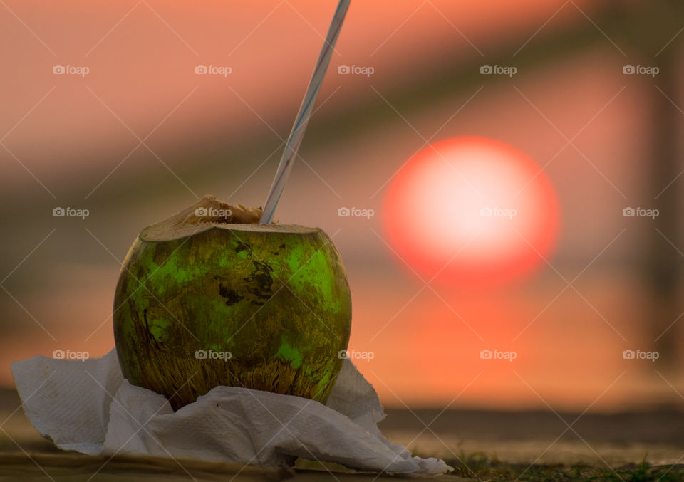 Close-up of coconut with straw