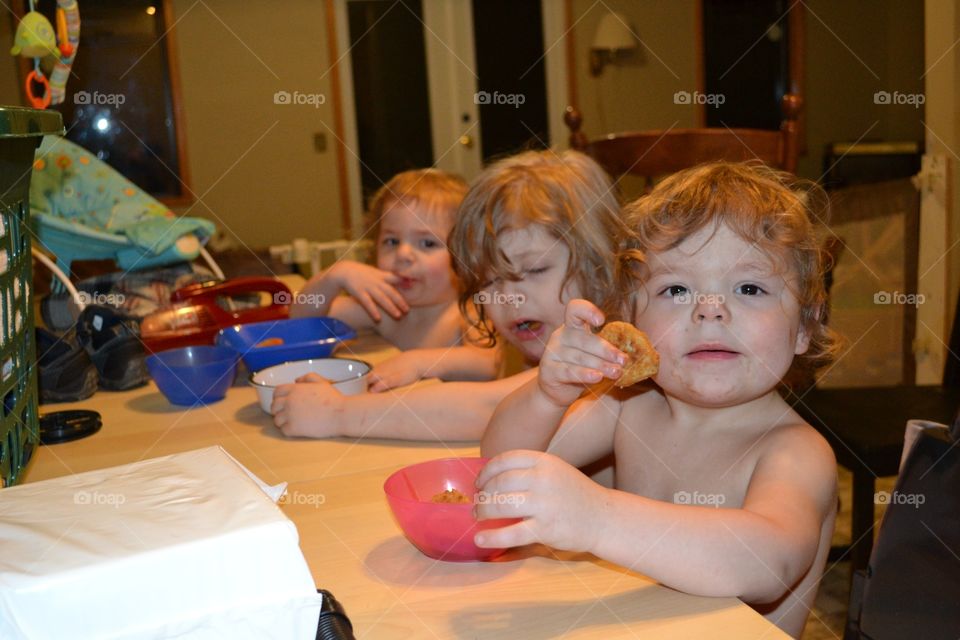 Sharing a meal.  Brothers sit at the table eating.  Caylen is 4 and The twin boys, Jayme and Caylen are 2 years old.