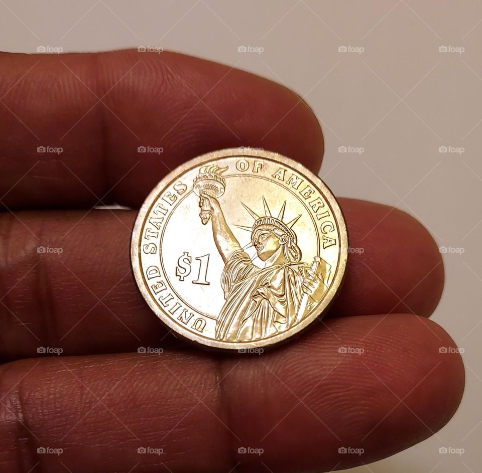 Circles are everywhere a $1 gold piece In hand of a collector