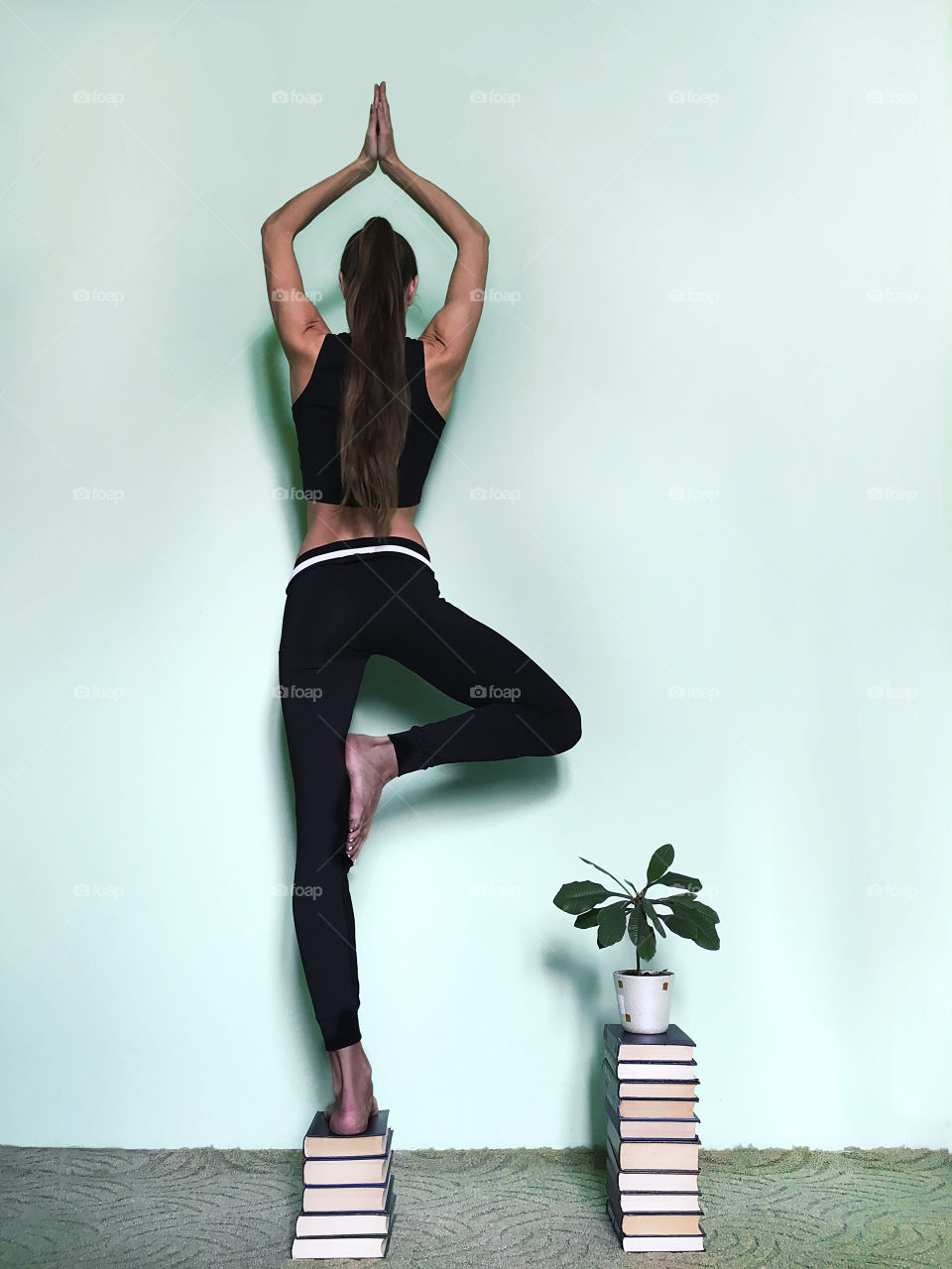 Young woman with long hair doing yoga at home 