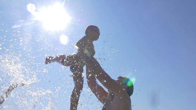 baby sea.  Dad tosses baby son up in the rays of the sun. family vacation by the sea