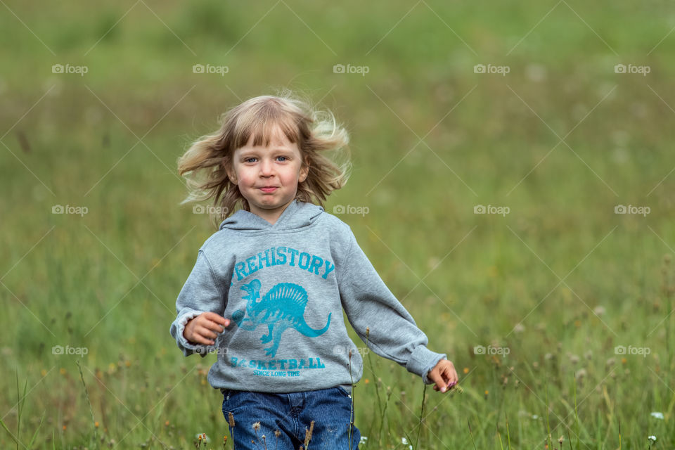 Cute little girl running in field
