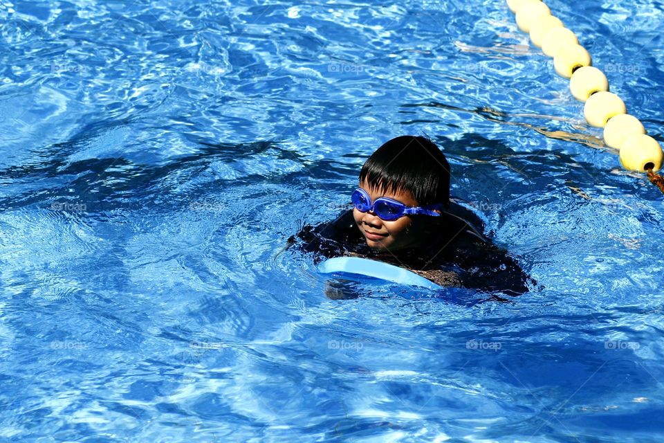 young kid swimming in a swimming pool