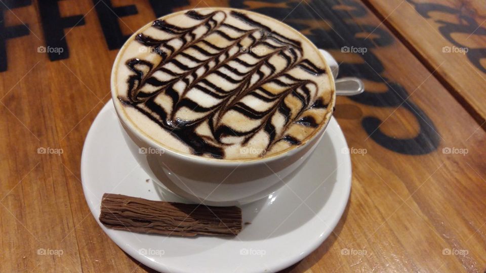 Coffee with chocolate on the side and on top