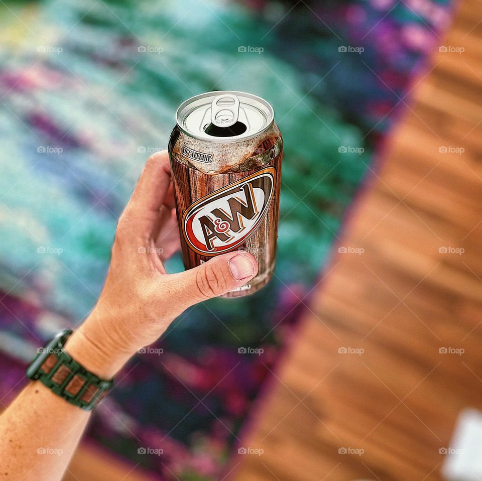 Hand holding A & W Rootbeer, drinking Rootbeer, enjoying a refreshment 