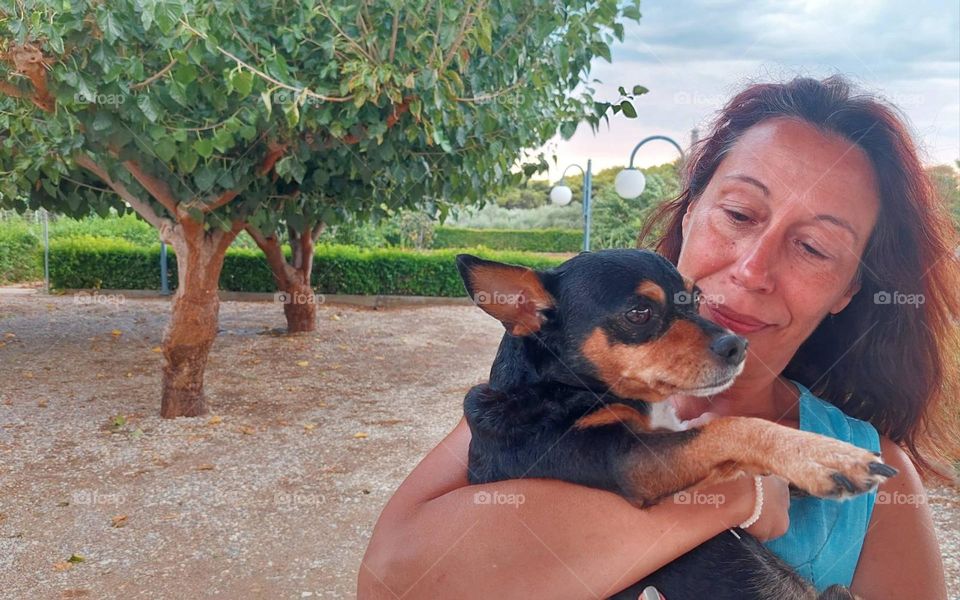 A woman holds a dog in her arms