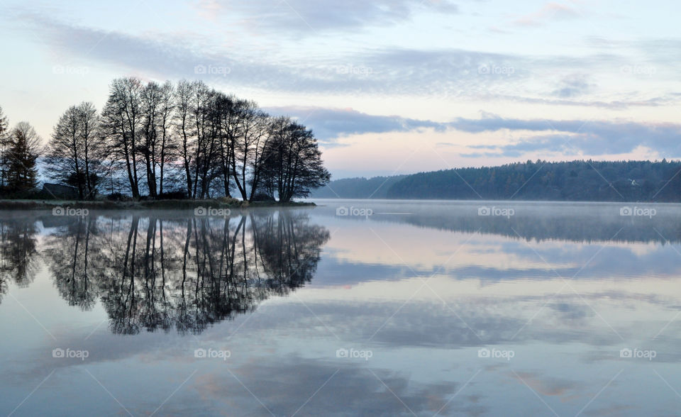 Reflection on sea against cloudy sky