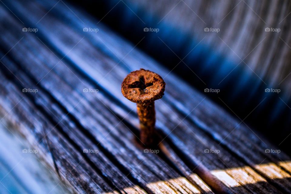 rusty screw sticking out of an old board