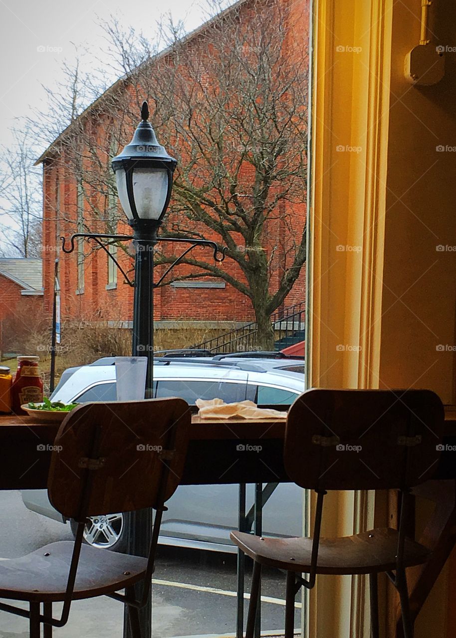 Inside a warm, cozy cafe looking outside on a very cold, raw early spring day in Vermont. 