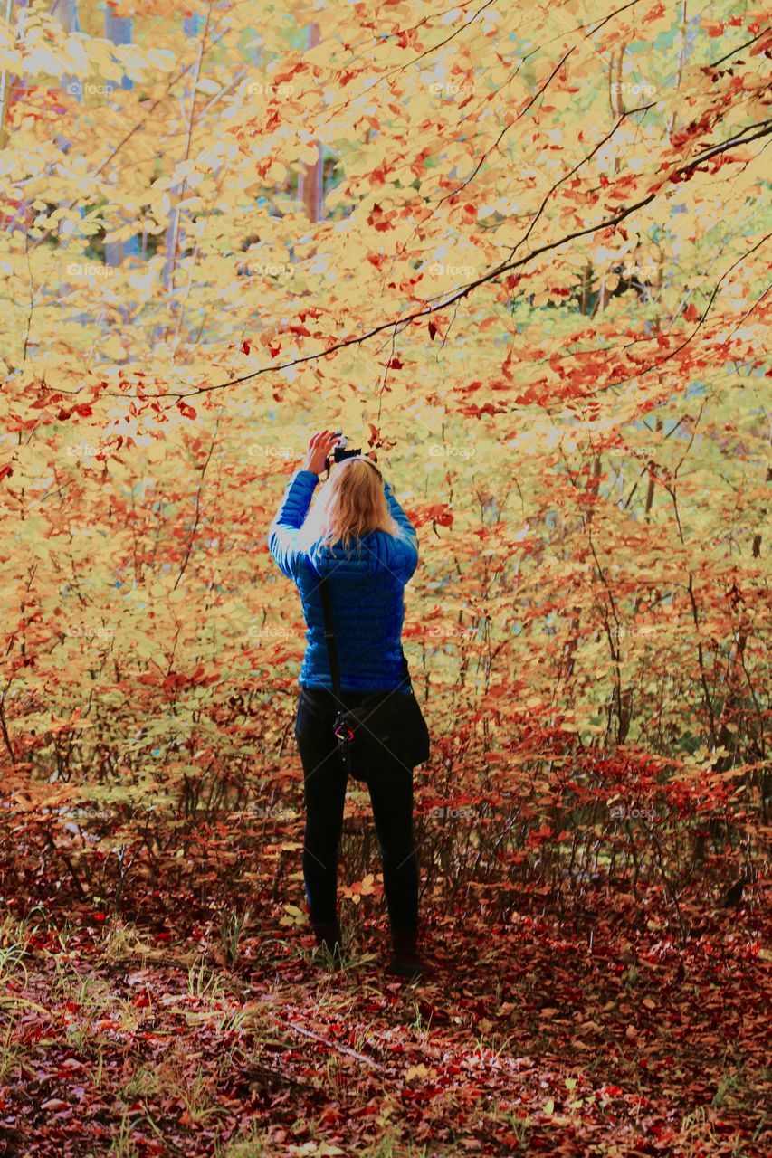 Woman enjoying taking photos in autumn 