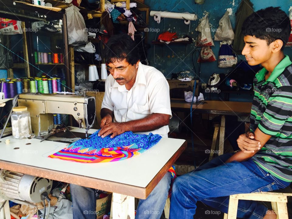 Close-up of indian tailor at work place with sewing machine