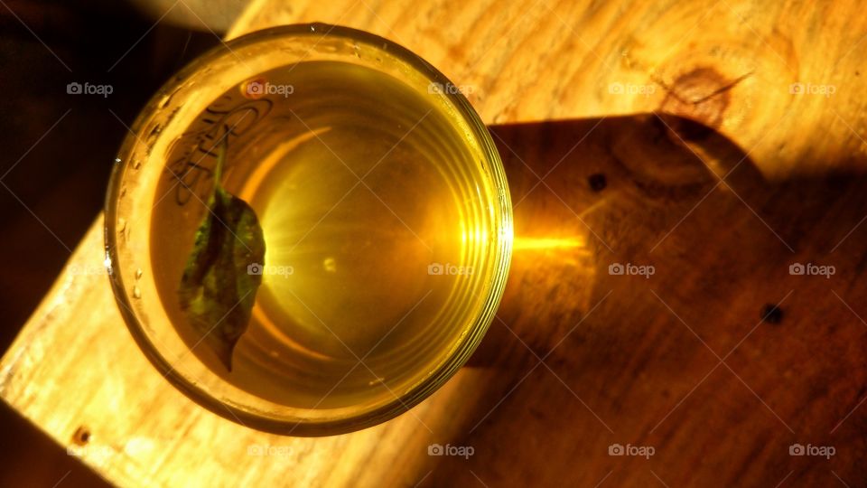 Copo de chá e reflexo da luz do sol.