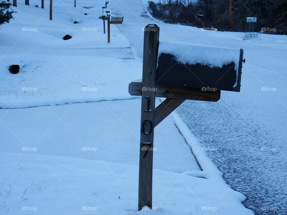Snowy mailboxes on empty road