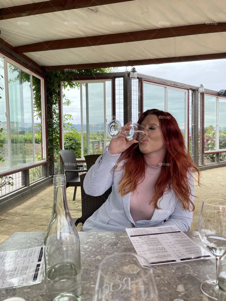 Sipping at a wine tasting in California, beautiful California winery backdrop. A brisk breeze blowing through my hair as my lips taste the last sip of that fruity wine.