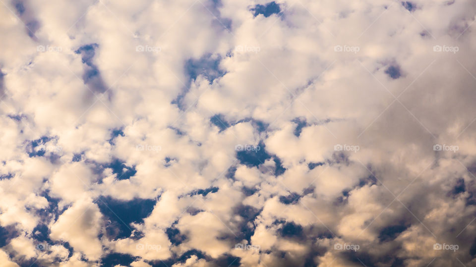 Large clouds float across the sunset sky like sails.