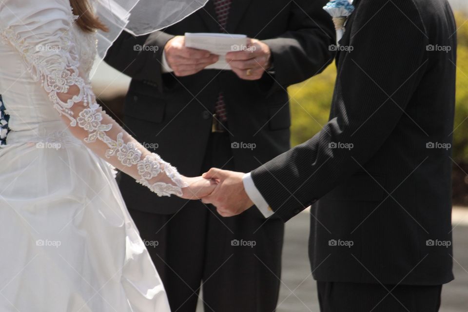 This beautiful couple said "I do" in an outdoor ceremony and held hands through much of it. 