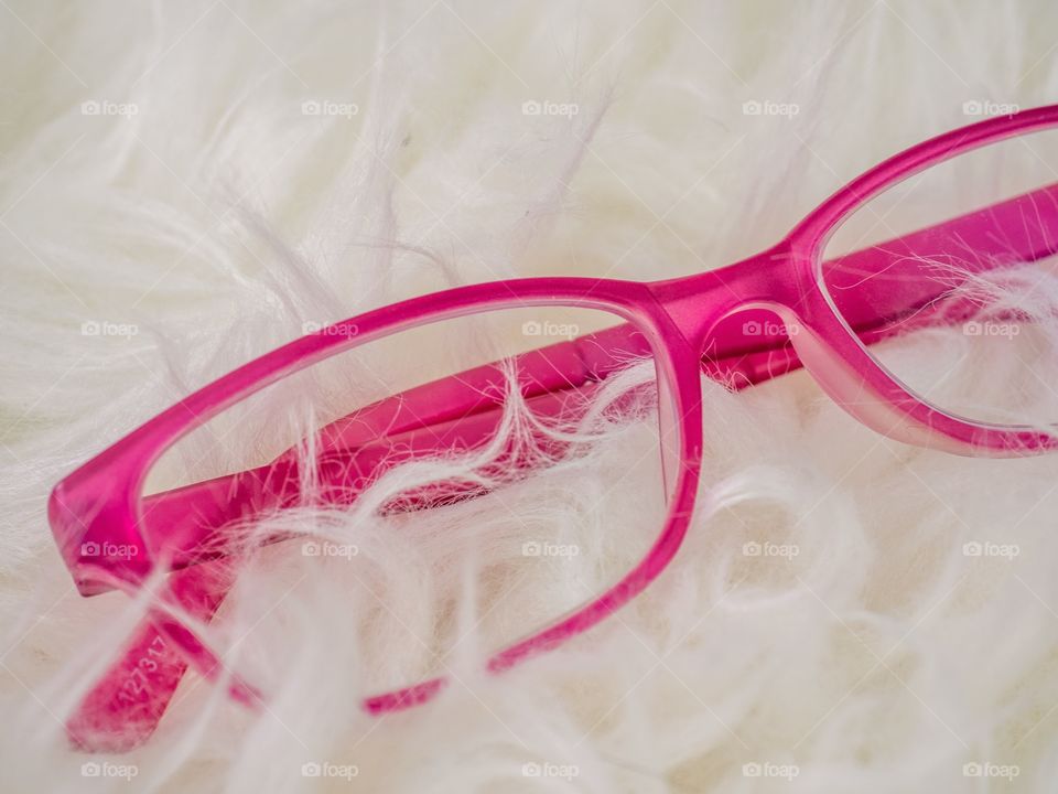 Pink glasses on white faux fur