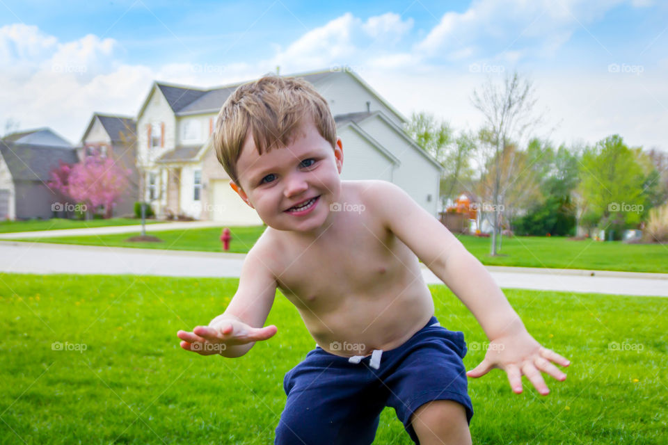 A shirtless little boy against house