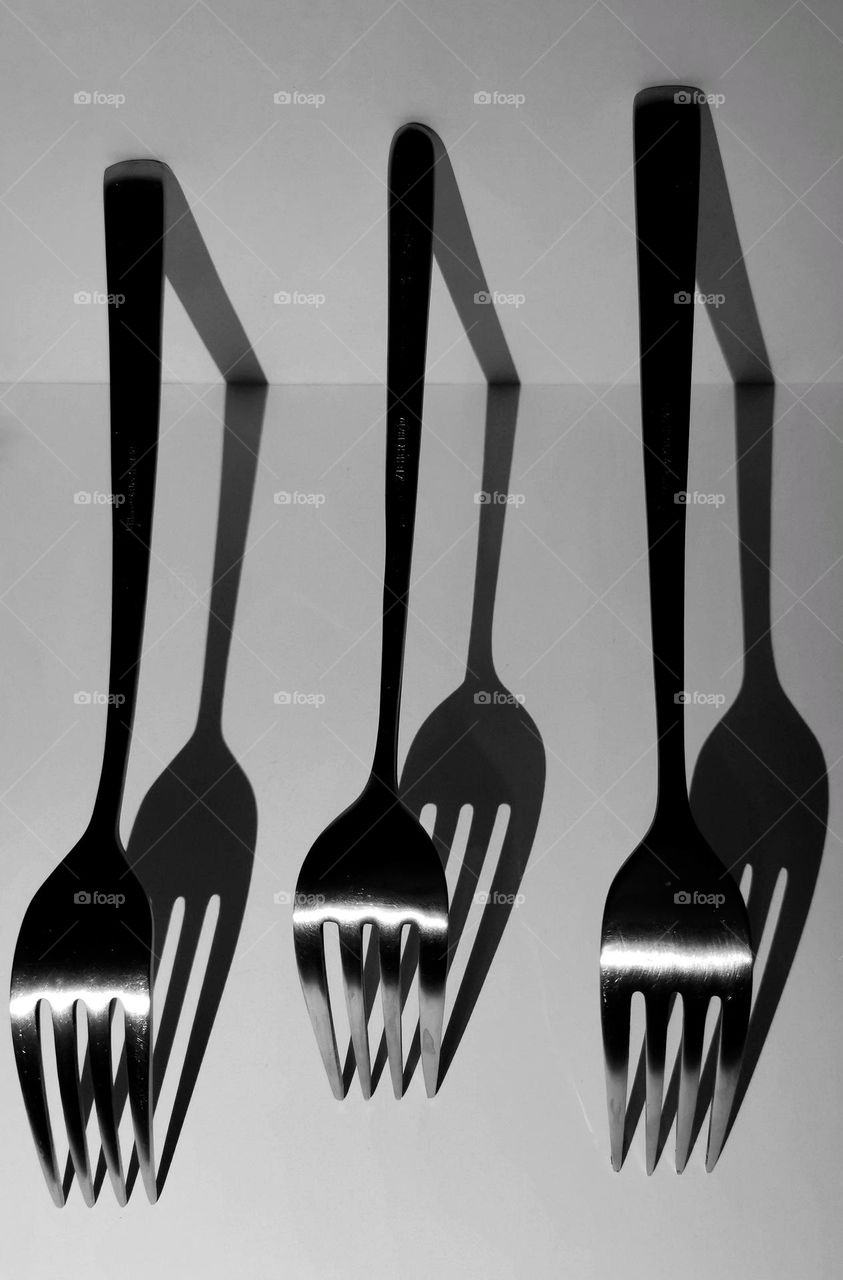 Black and white photography. Metal forks and their shadows.