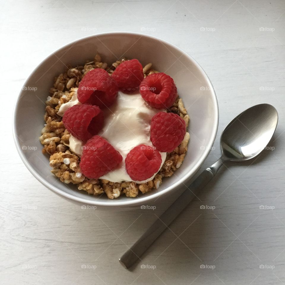 A healthy lunch with granola, raspberries and yogurt help the day go by fast
