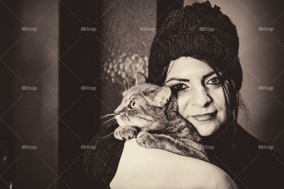 Black and white photo of a woman and cat hugging
