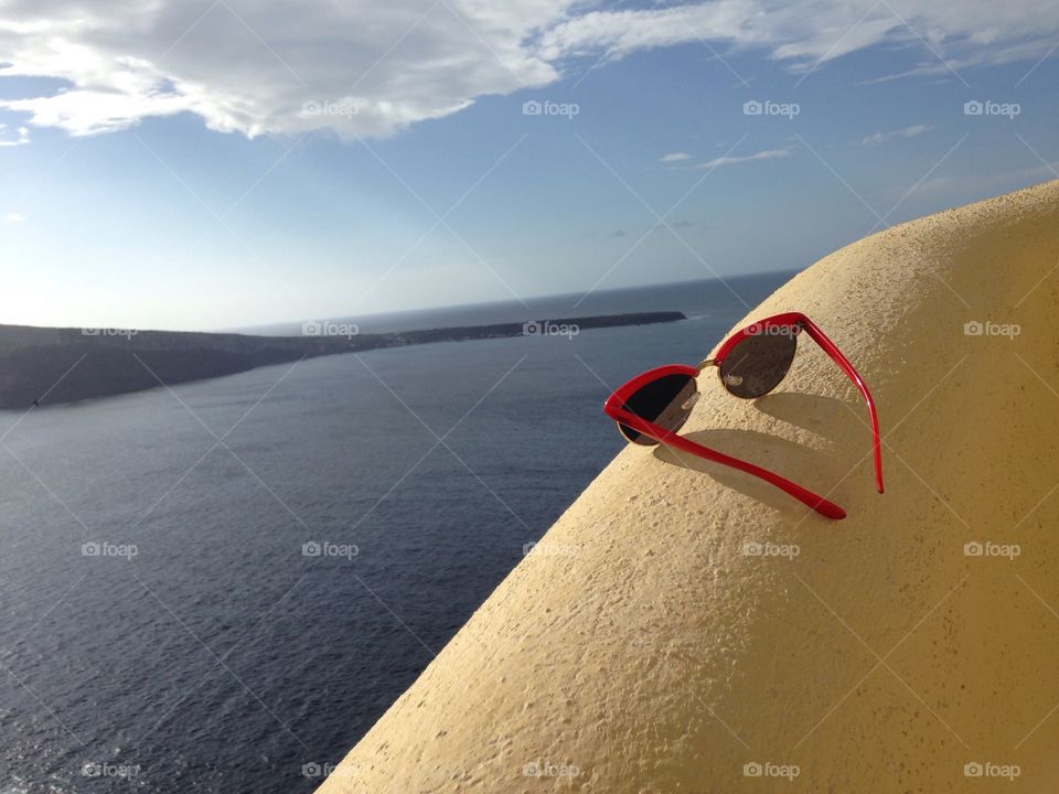 Sunglasses on rock in front of sea