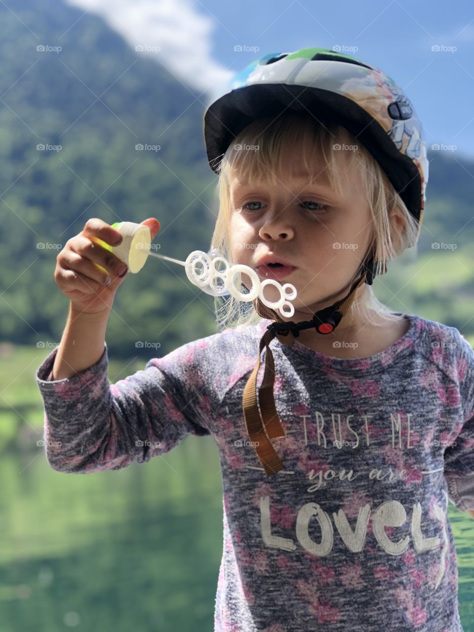 girl blowing bubbles on a lake in Switzerland