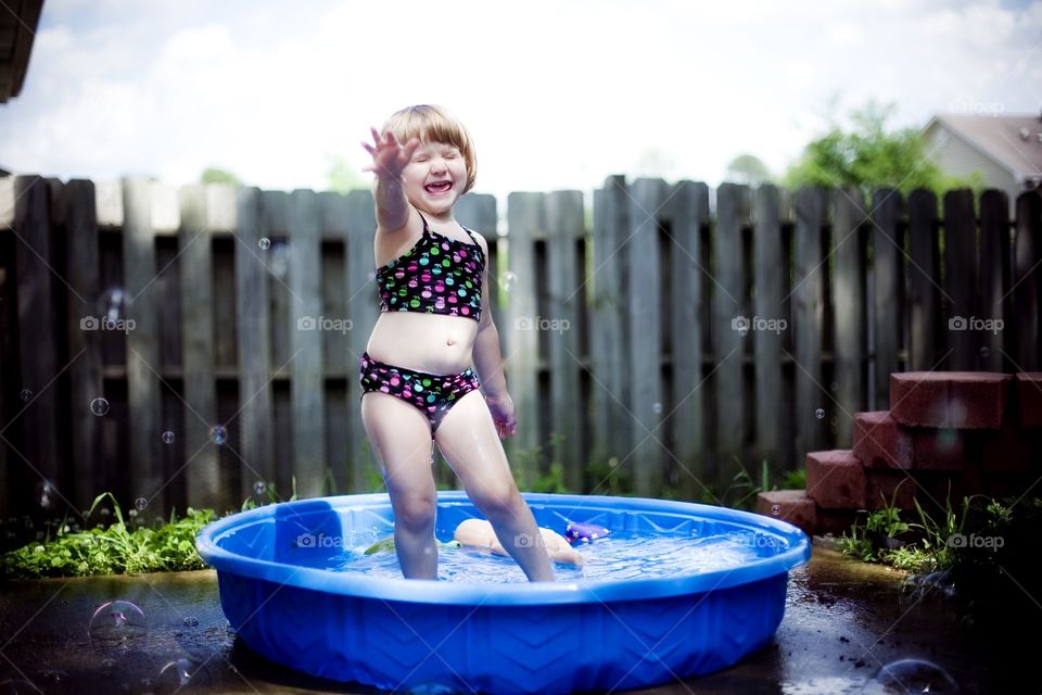 Portrait of crying girl standing in tub